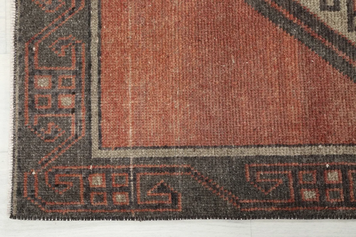 Corner detail showing the hand-knotted texture and the charcoal border design