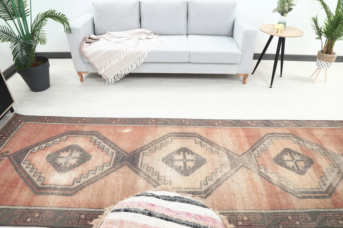 Overhead view showing the series of charcoal and beige geometric medallions on the rust rug