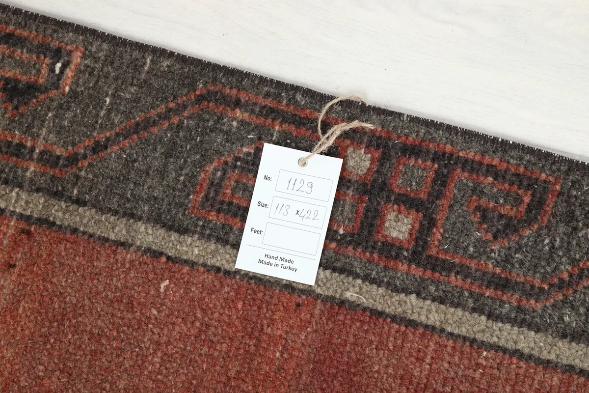 Detail of the rug tag showing dimensions and origin, placed on the charcoal border