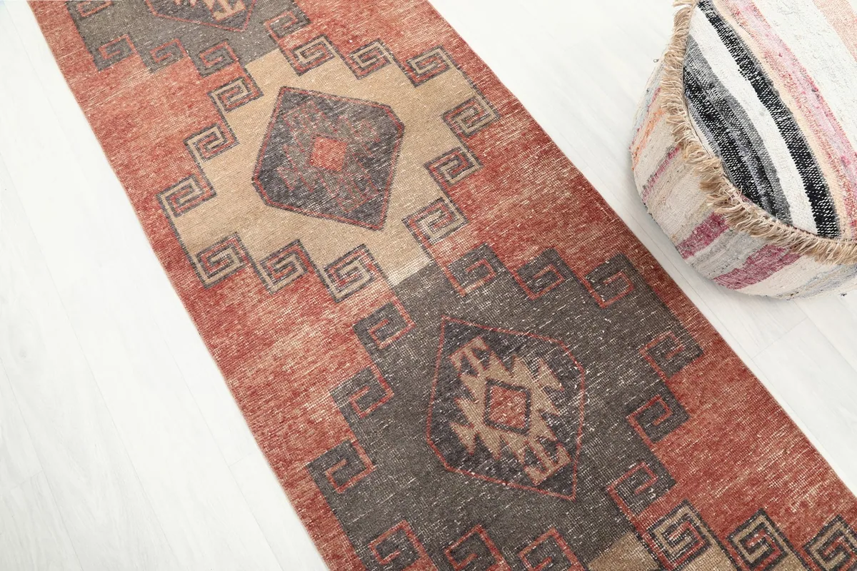 Diagonal view of the runner's surface, emphasizing the texture and subtle color variations in the rust and charcoal.