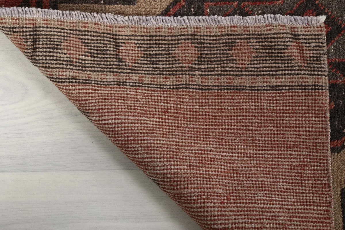 Close-up of the back of the runner, displaying the tight weave of the cotton foundation and the fringe.