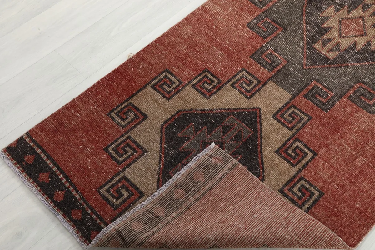 Corner of the runner folded back to show the cotton foundation and the reverse side of the hand-knotted wool.