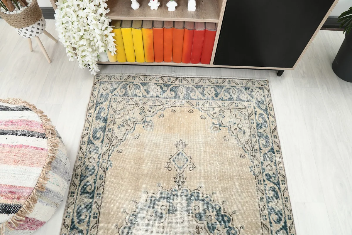 View looking down the length of the tan and blue runner rug in a room.