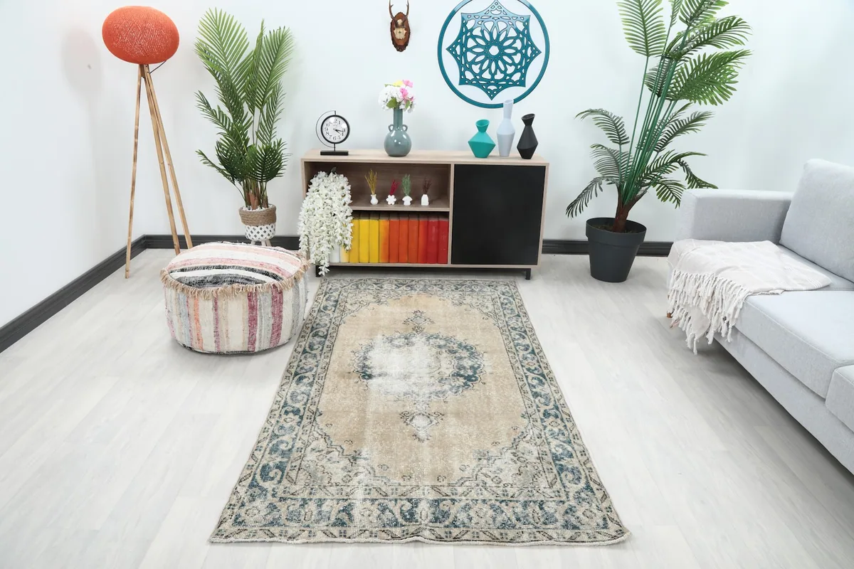 Vintage tan and blue runner rug in a bright living room setting with a sofa and pouf.