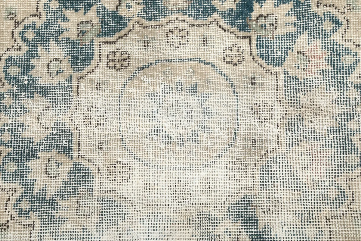 Close-up showing the low pile and intricate knotting of the vintage wool rug.