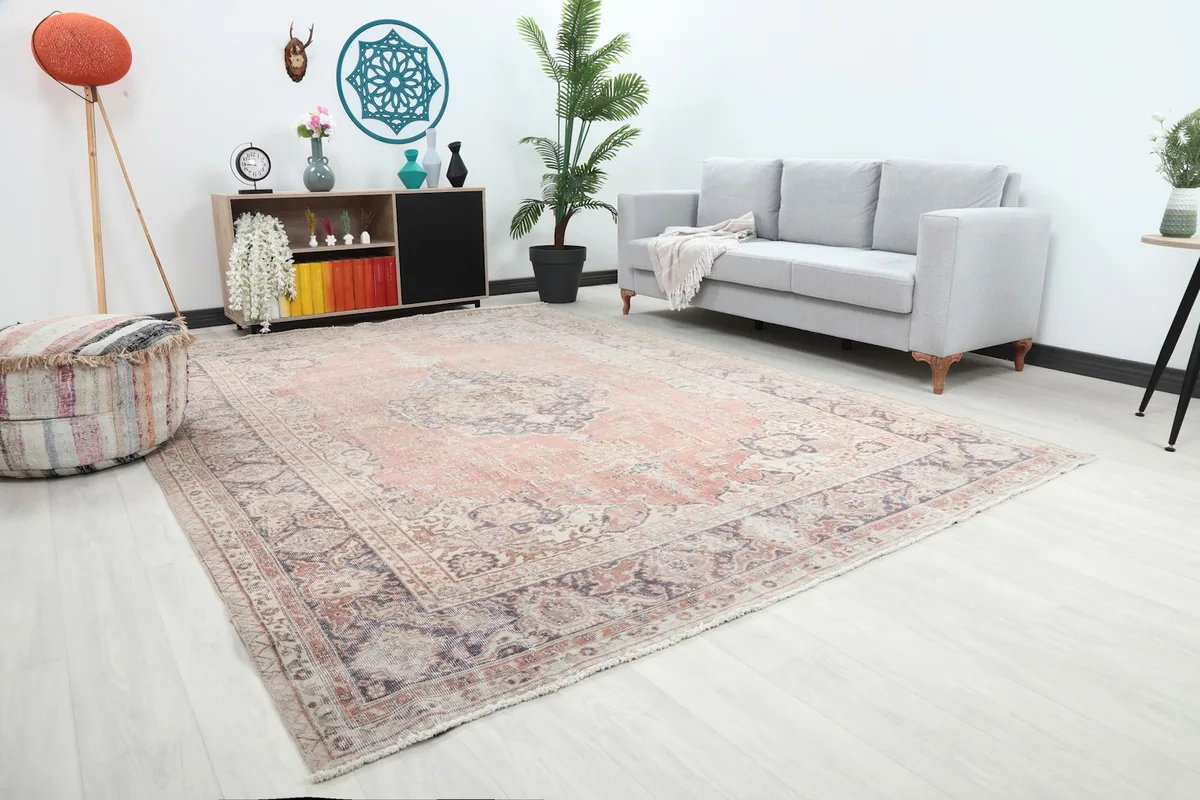 Angle view of the hand-knotted rose and navy rug in a bright living space