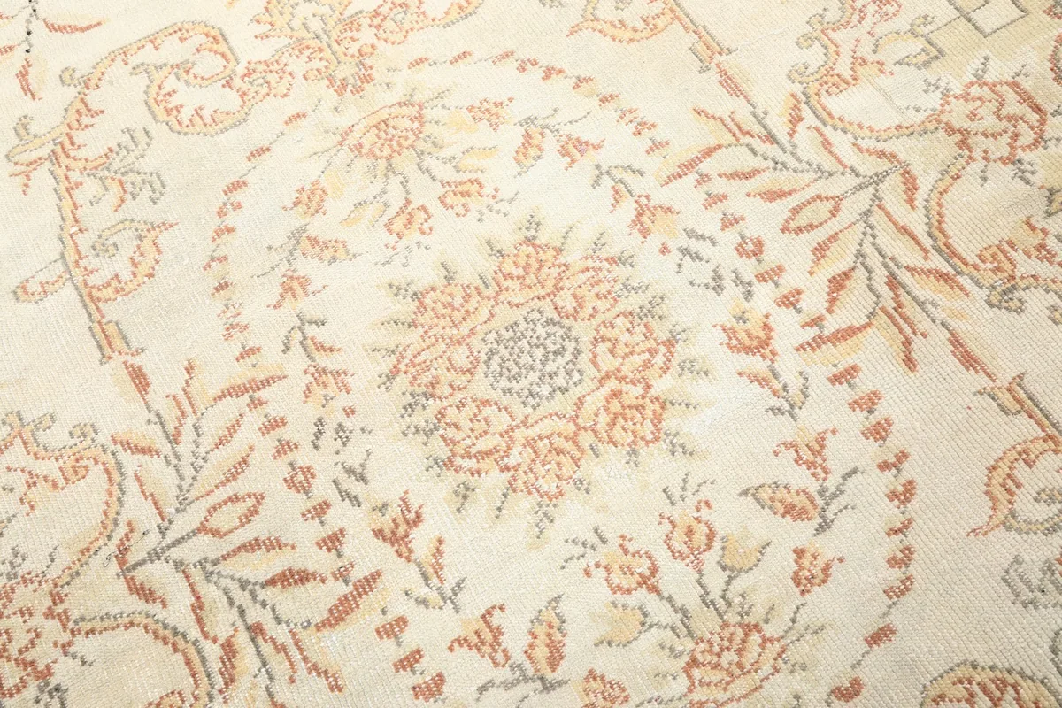 Close-up of the central floral medallion with rose, rust, and blue details