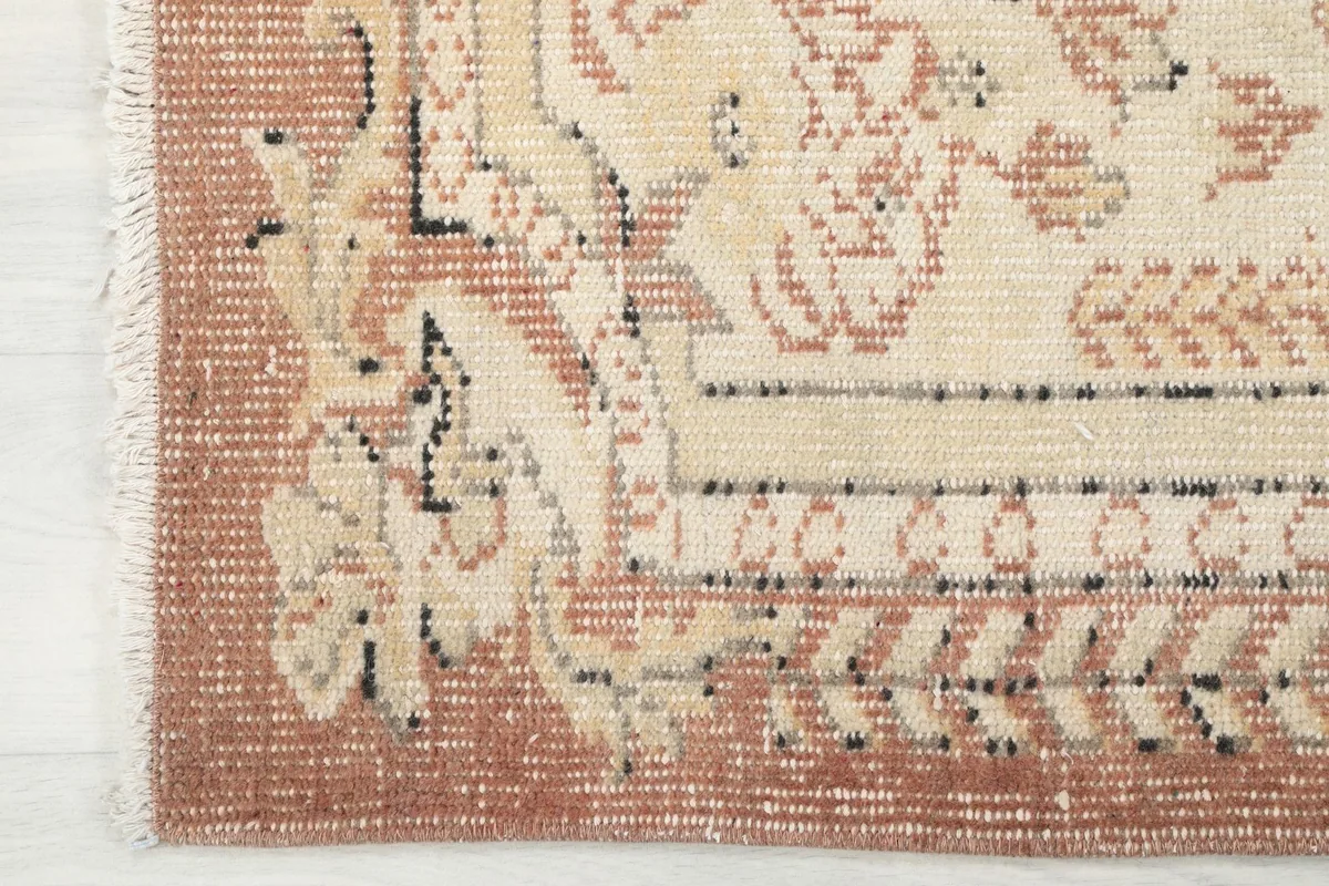 Close-up of the rust-colored border and fringe, showing the hand-knotted texture