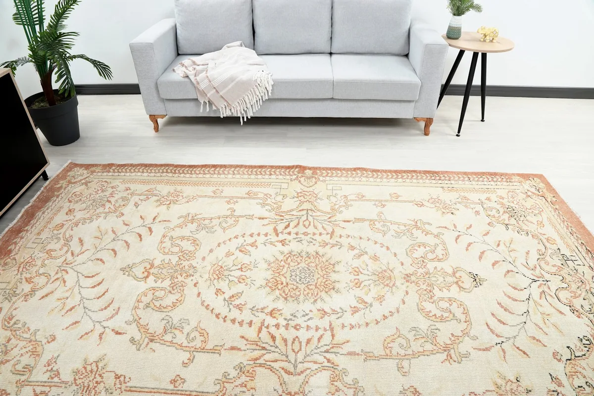 Overhead view of the rug in a room, highlighting the central floral medallion and border