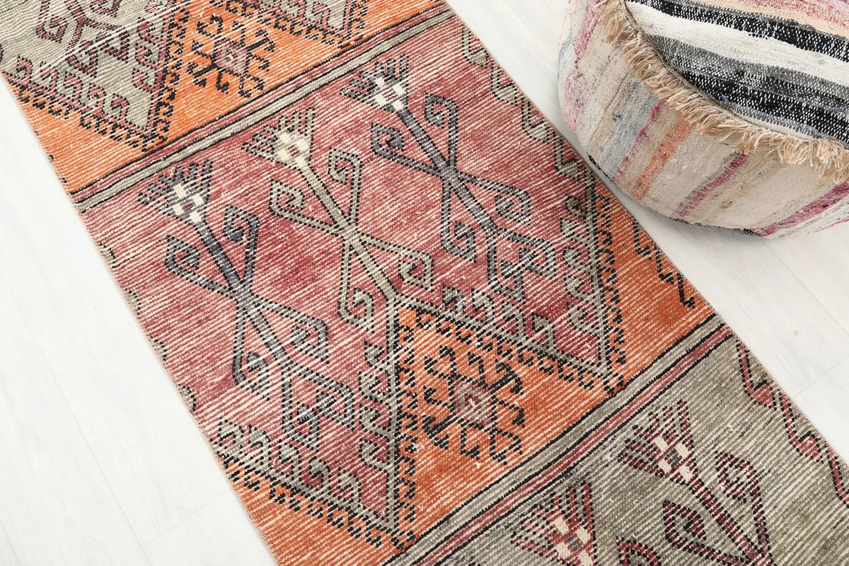 Close-up detail of the rust, gray, and orange geometric motifs on the runner's surface