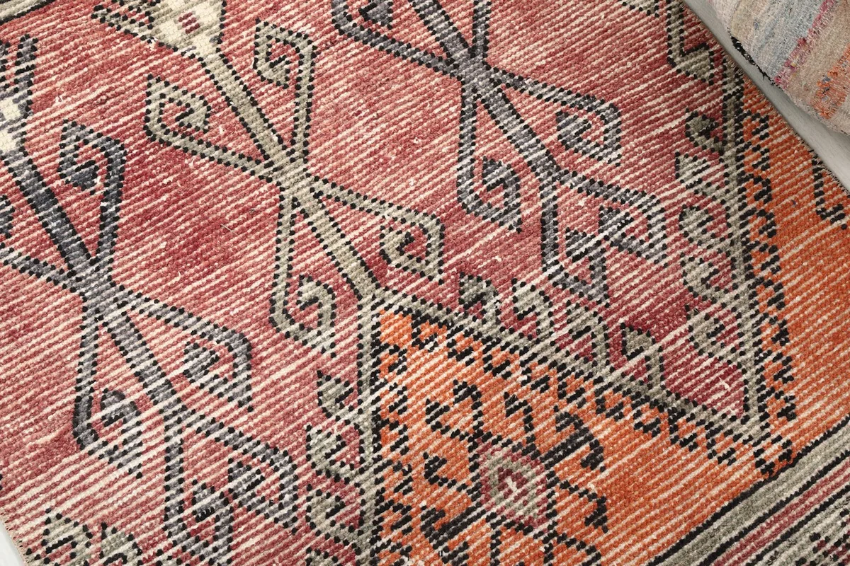 Detailed view of the hand-knotted wool pile, showing vintage wear and color variations