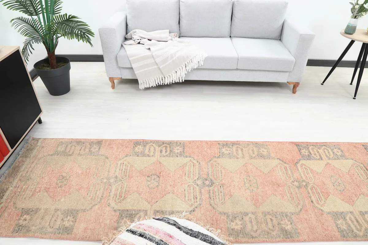 Overhead view of the vintage rug in a living space, emphasizing its long runner shape and patterns.