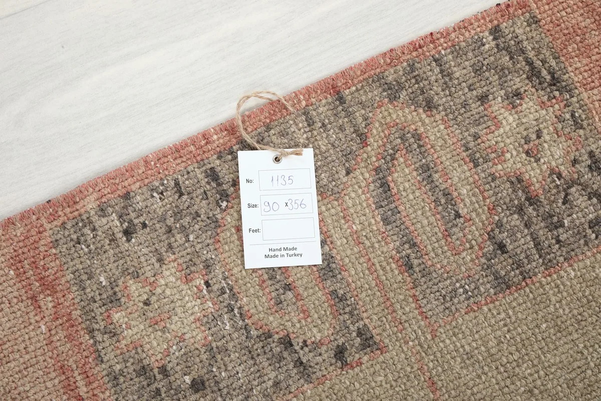 Close-up of the product tag attached to the vintage Anatolian runner rug, showing its origin.