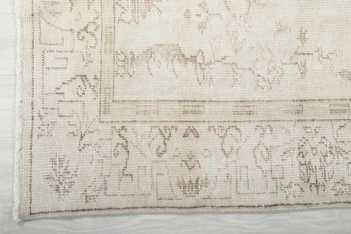 Detail of the outer border and corner design of the cream and beige vintage rug