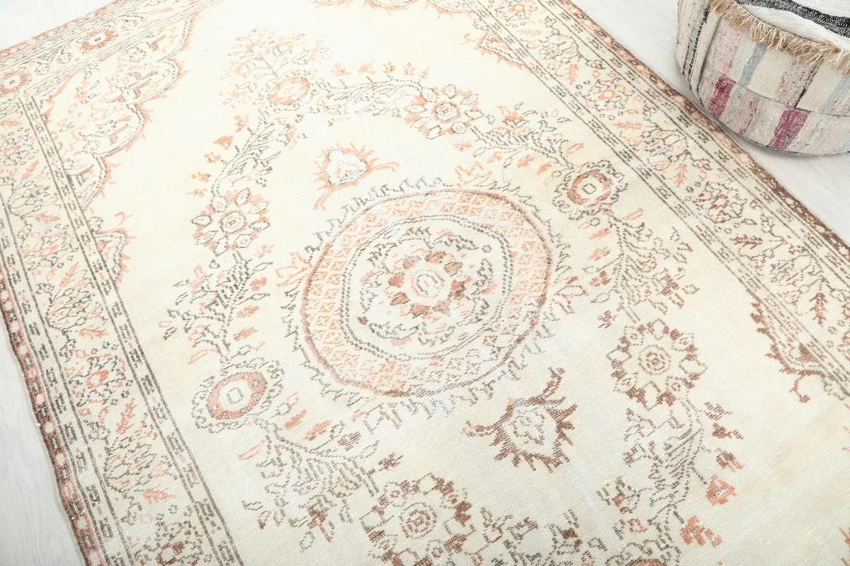 Detailed view of the central medallion and surrounding floral motifs in rust and brown