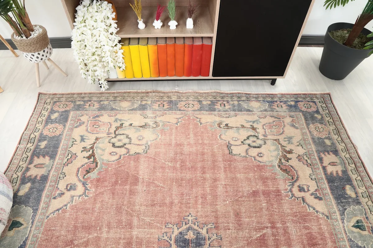 Detail view of the top section of the rose and navy rug, showing the border and corner motifs
