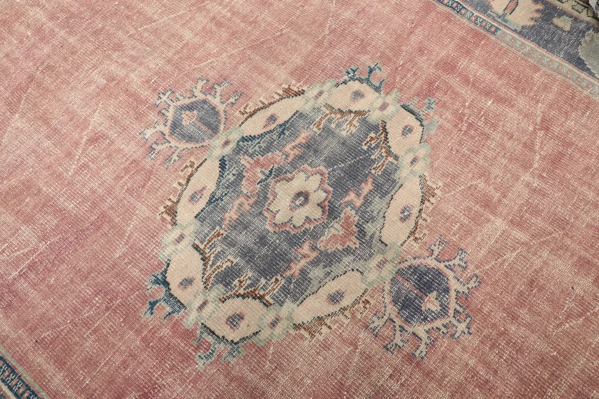 Detailed close-up of the central navy and beige medallion design on the rose field
