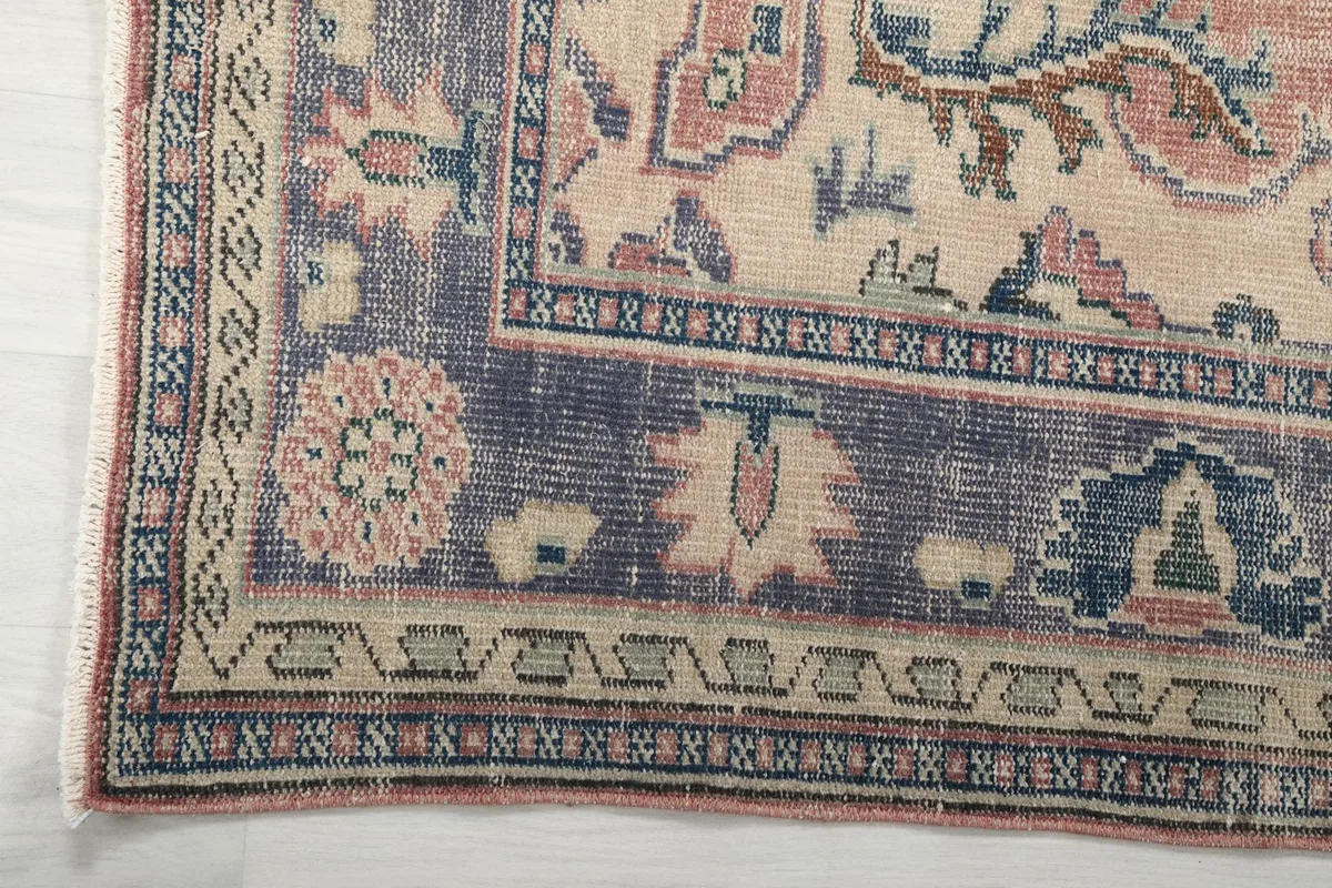 Close-up of the detailed navy border with floral and geometric patterns, showing edge wear