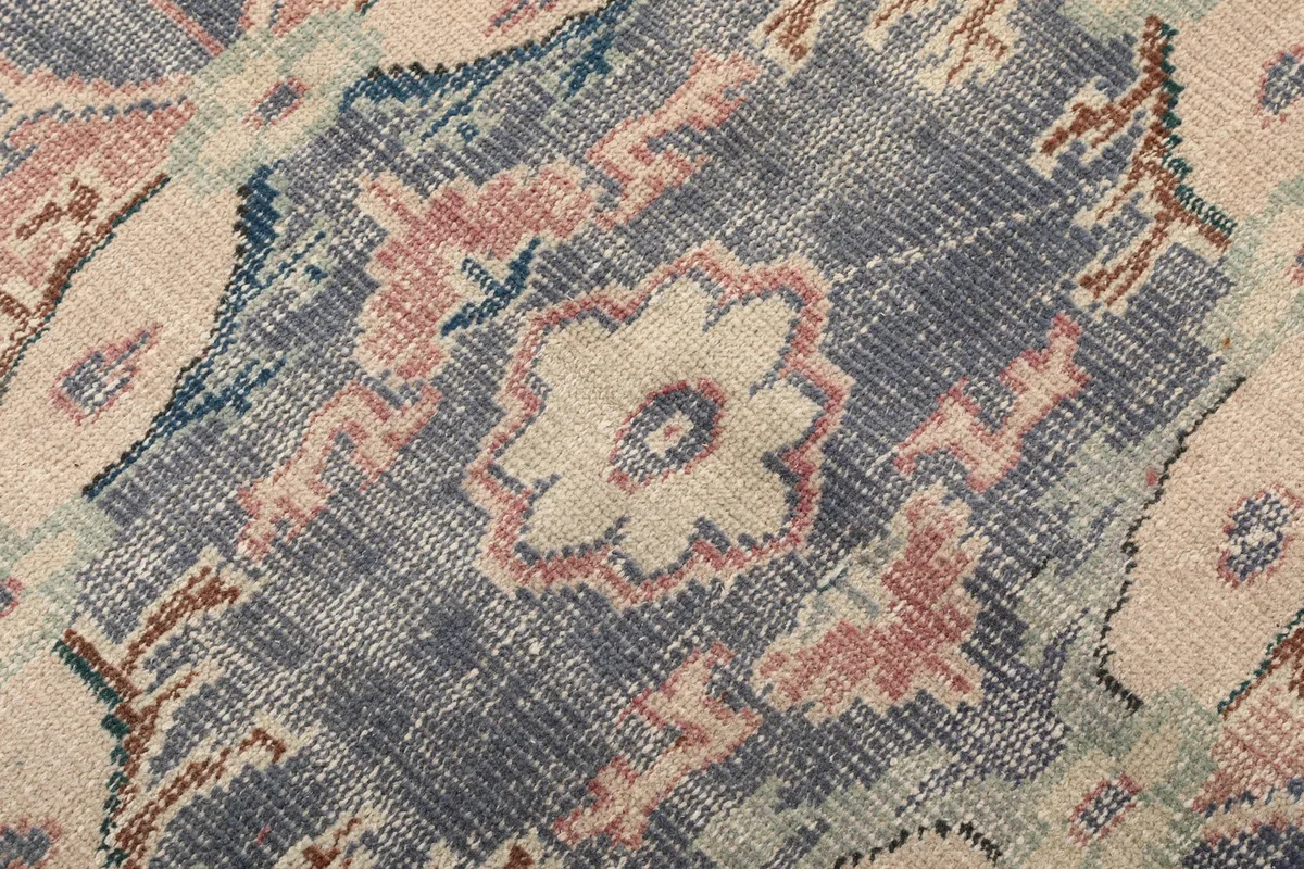 Extreme close-up showing the low pile texture and intricate knotting of the wool rug