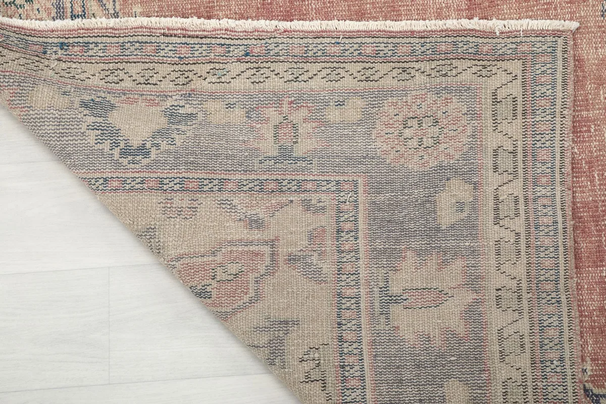 Close-up of the rug's back, showing the hand-knotted cotton foundation and wool pile
