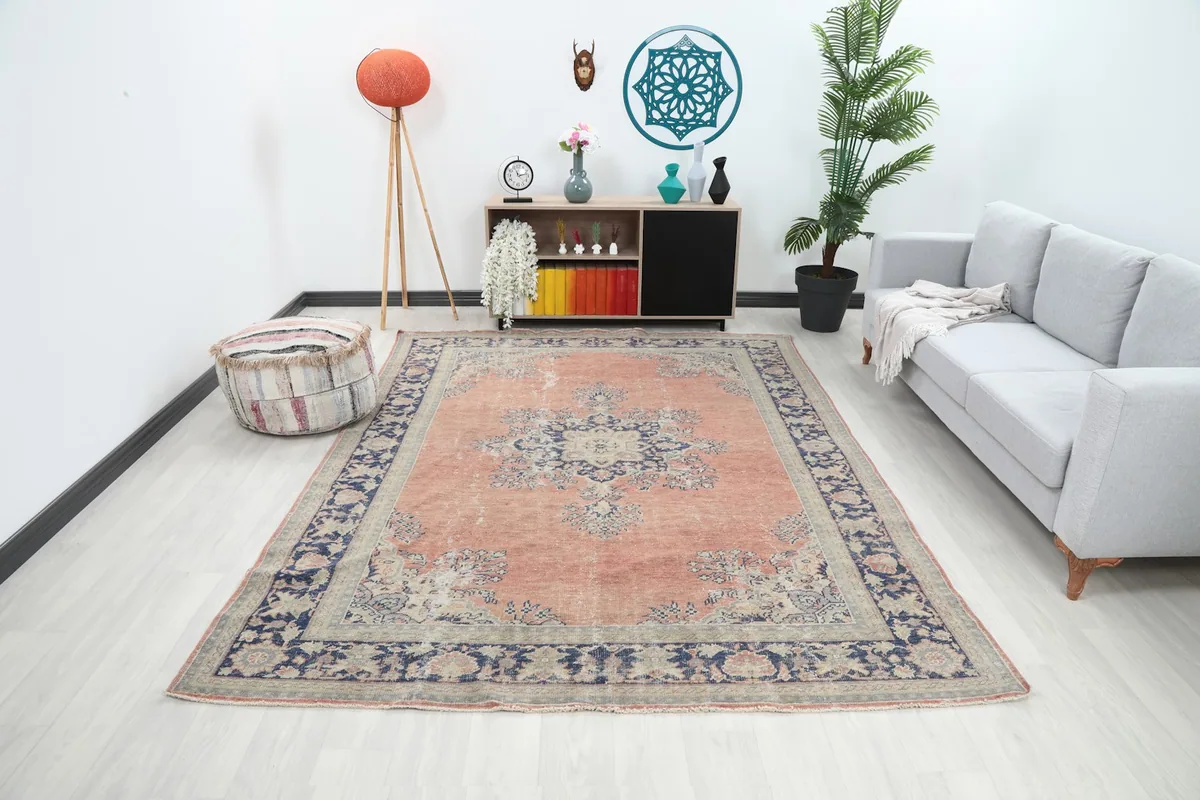 Vintage Anatolian rug displayed in a bright living room setting with a sofa and cabinet