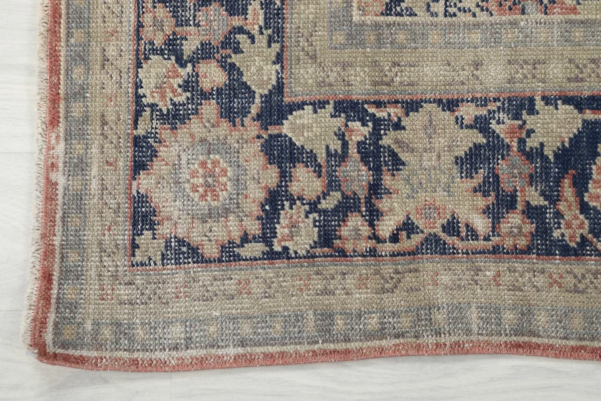 Detailed view of the rug's navy floral border and outer edge