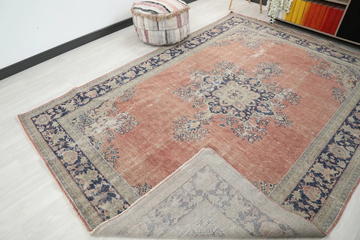 Corner of the rug folded back, showing the cotton foundation and reverse side of the border