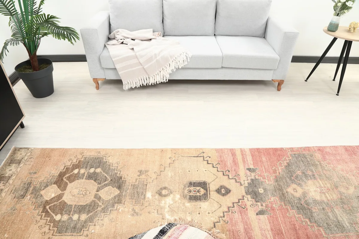 Overhead view of the rug in a room, capturing its full pattern and scale next to a sofa.