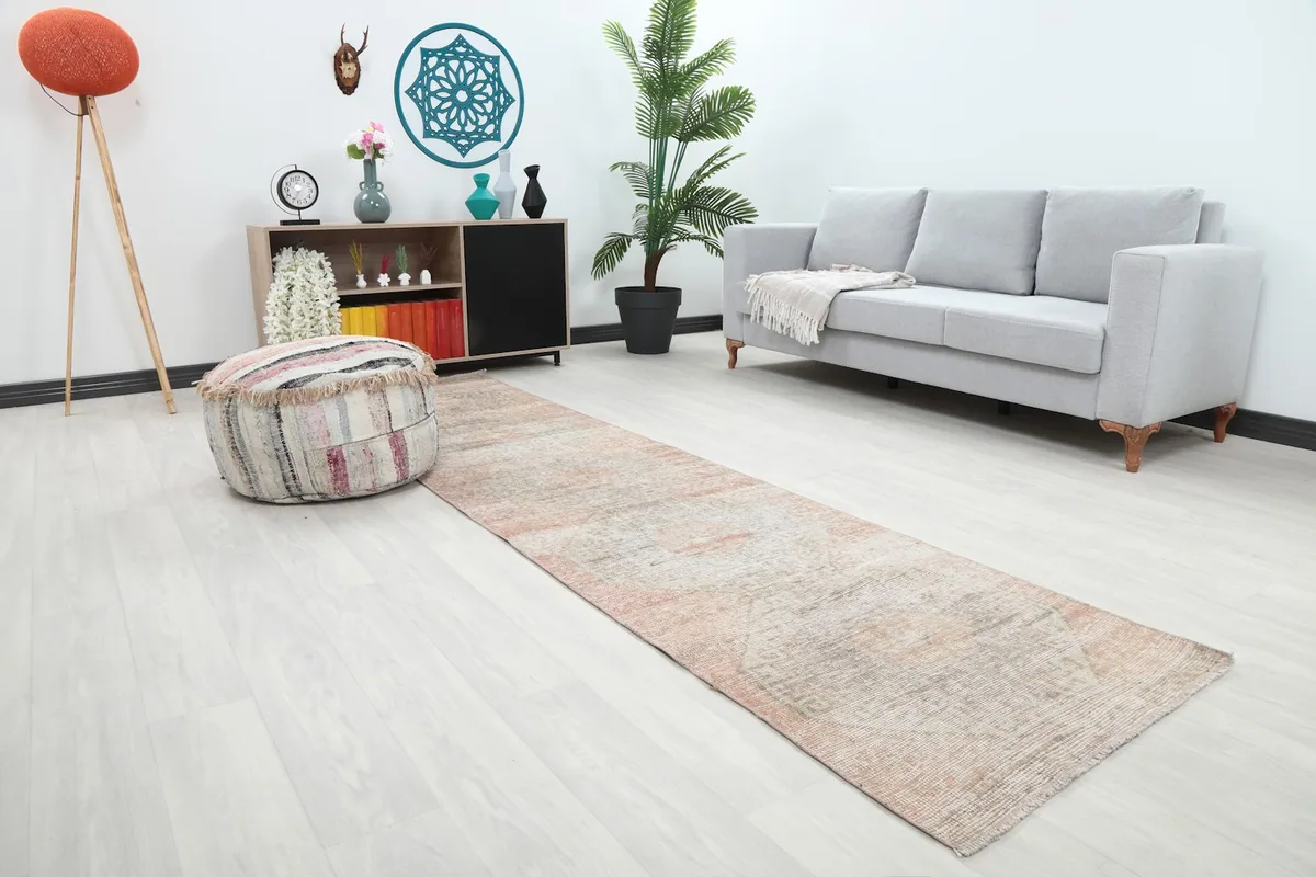 Angle view of the geometric runner rug in a long hallway, showing its length and muted colors