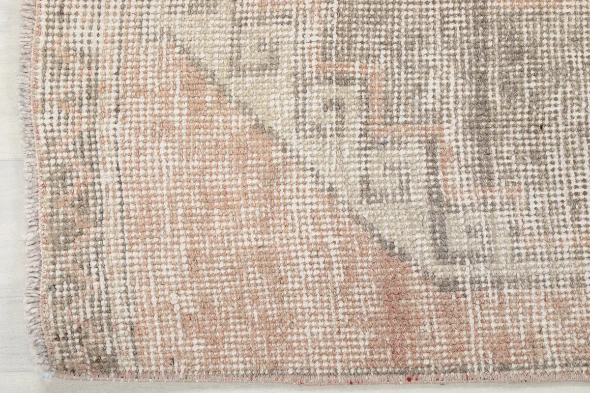 Corner detail of the runner rug, revealing the subtle geometric motifs and color blend