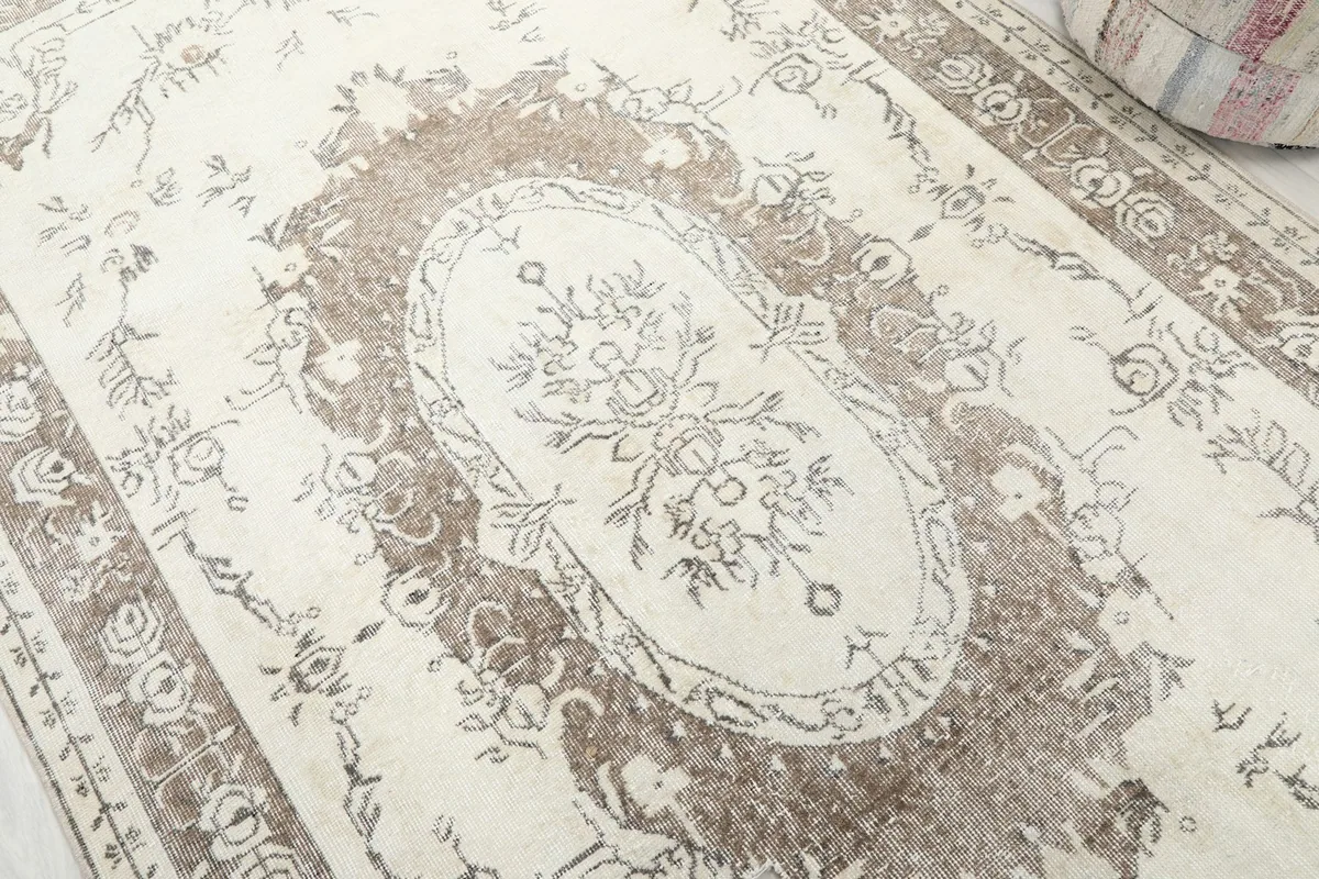 Close-up of the central floral medallion and surrounding ivory field, highlighting the subtle design and texture