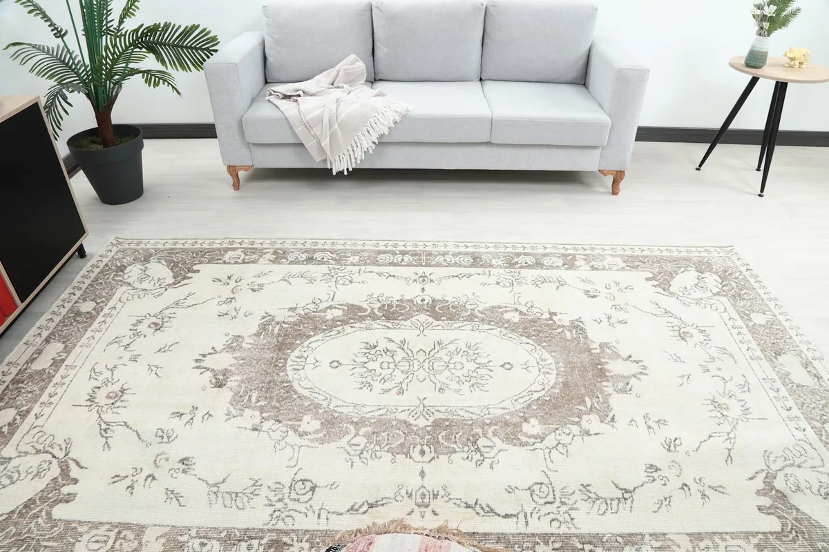 Overhead view of the ivory and beige vintage rug in a staged room, showing its full design and scale