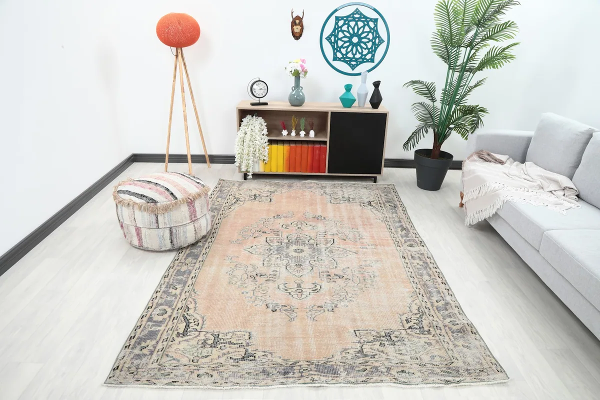 Vintage Anatolian rug in a modern living room setting with a gray sofa and pouf