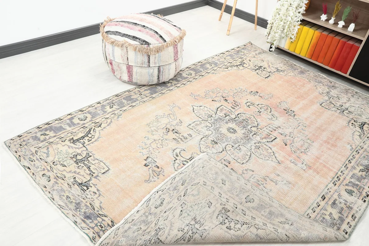 Corner of the rug lifted to show the back of the hand-knotted wool pile on cotton foundation