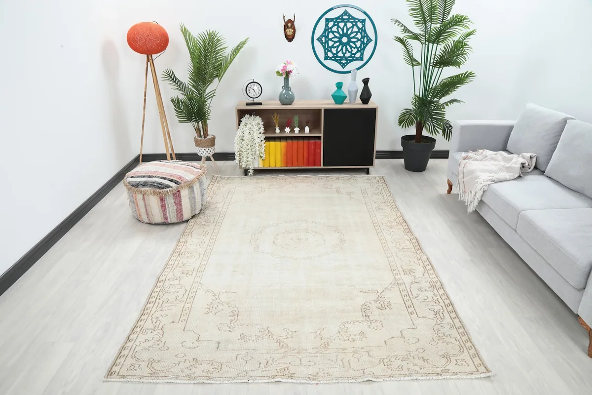 Vintage ivory and beige wool rug displayed in a modern living room setting with a light gray sofa.