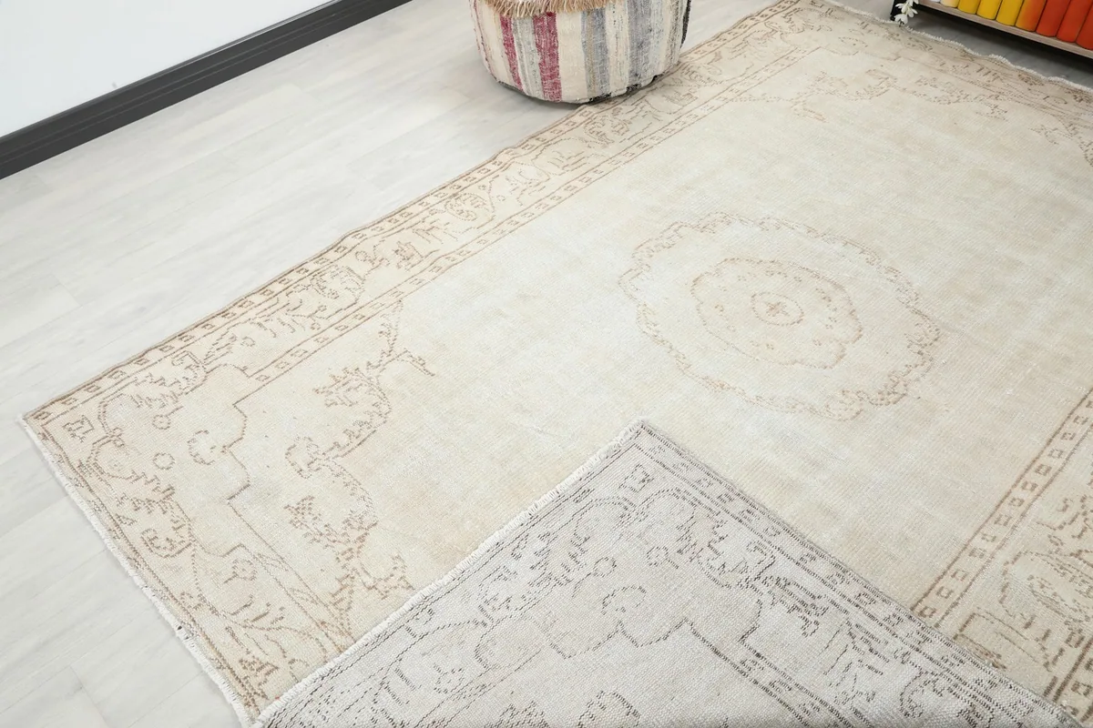 View of the rug with a corner folded back, revealing the reverse side and showing the hand-knotted construction.