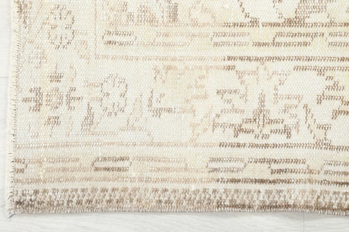 Detailed view of the outer border design and the edge of the hand-knotted rug.