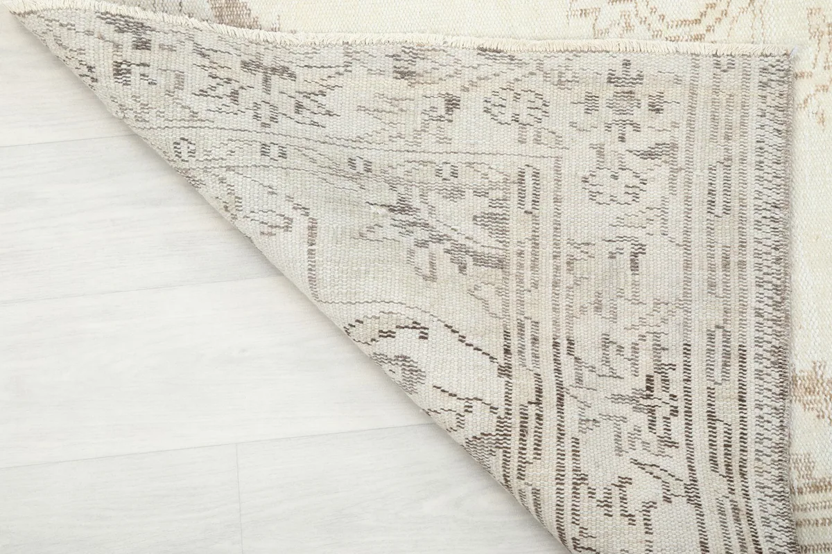 View of the underside of the rug, showing the cotton foundation and hand-knotted construction.