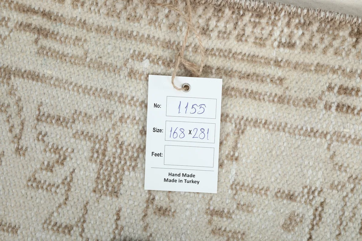 Close-up of the product tag attached to the rug, indicating its size and origin.