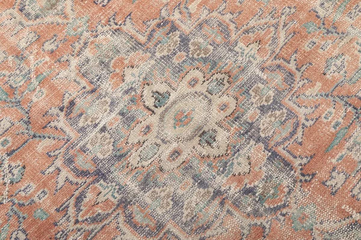 Detailed view of the intricate patterns and colors within the rug's central medallion
