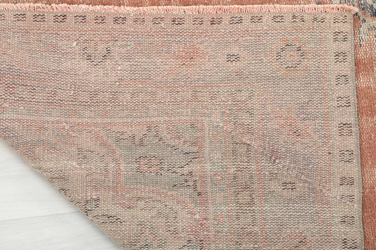 Underside view of the rug, revealing the tightly woven cotton foundation and knotting