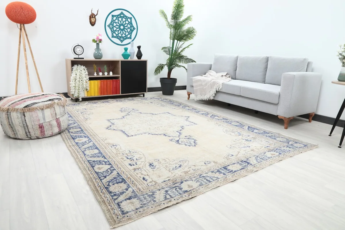 Angle view of the beige and blue vintage rug furnishing a living space