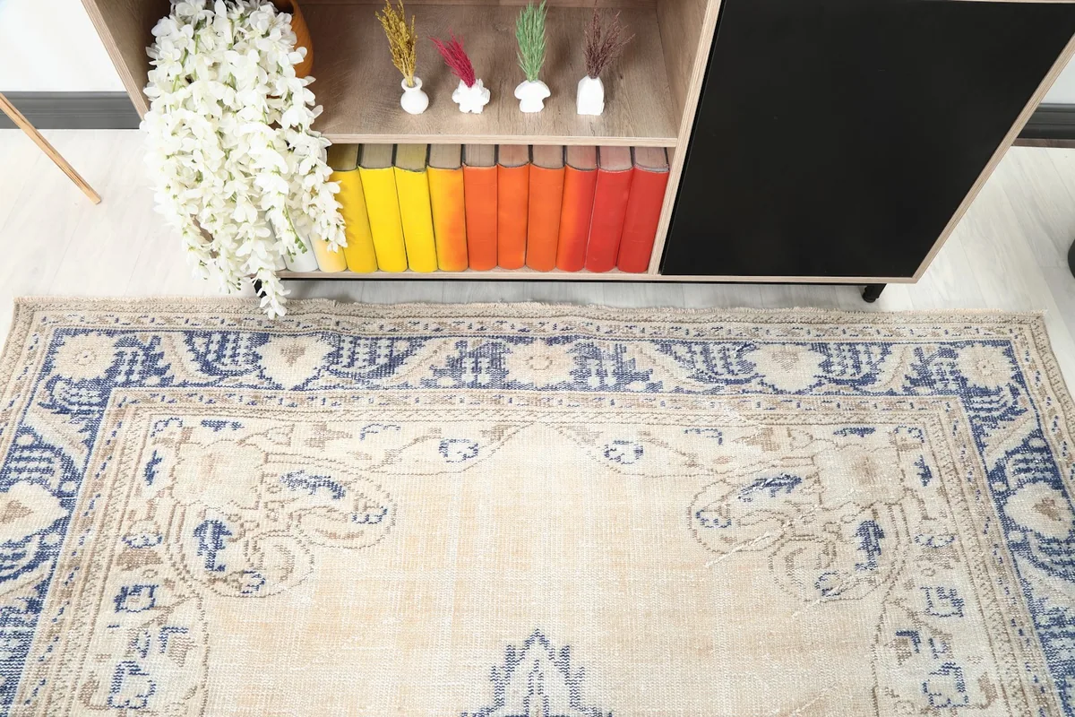 Close-up of the upper border and corner of the beige and blue vintage rug