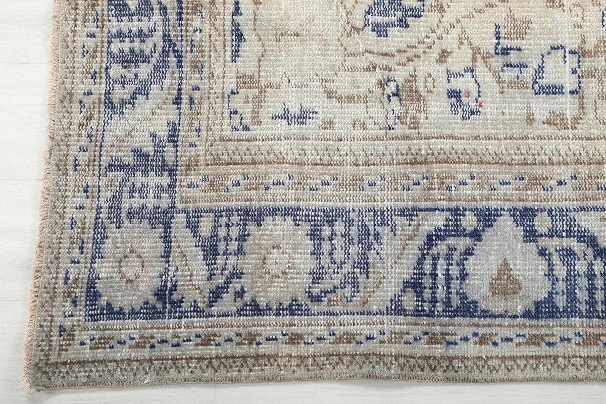 Corner detail showing the intricate blue and beige border design and texture