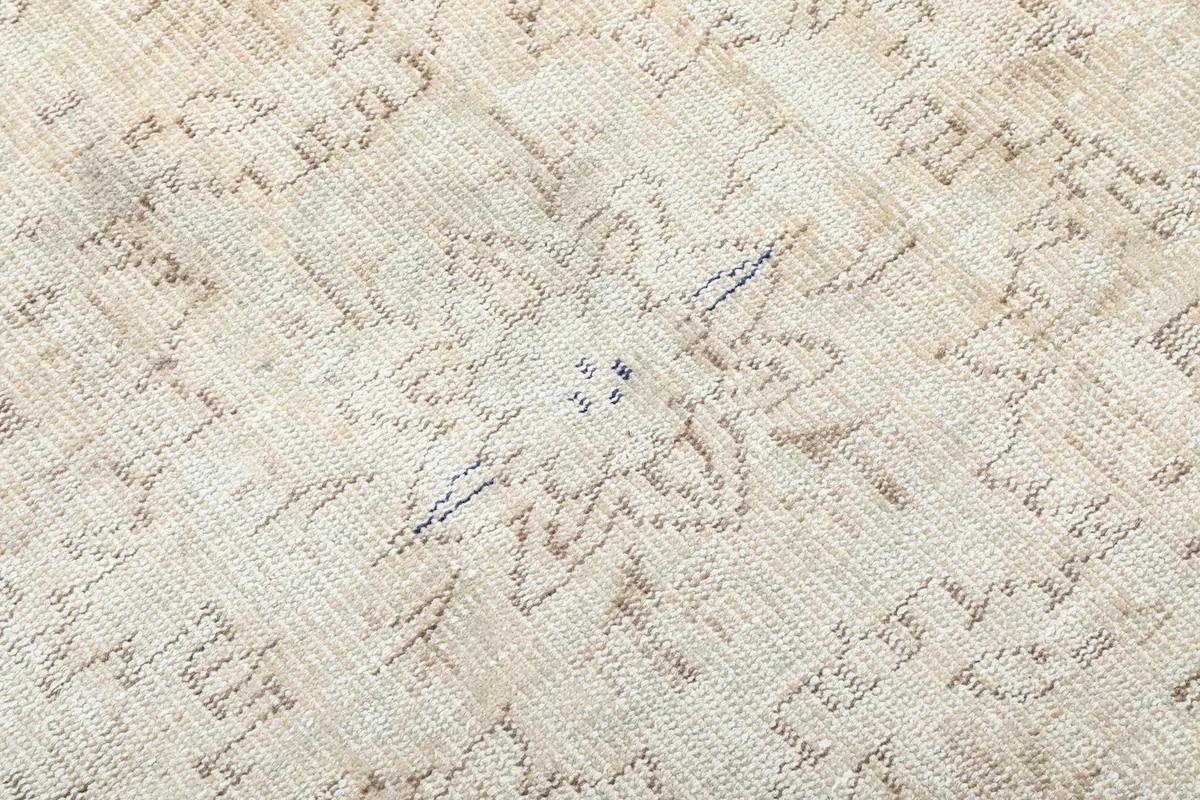 Close-up of the low wool pile and faded patterns of the vintage rug