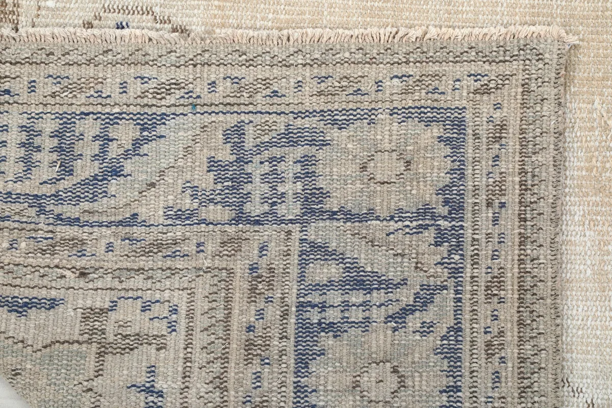 View of the back of the rug, revealing the hand-knotted cotton foundation