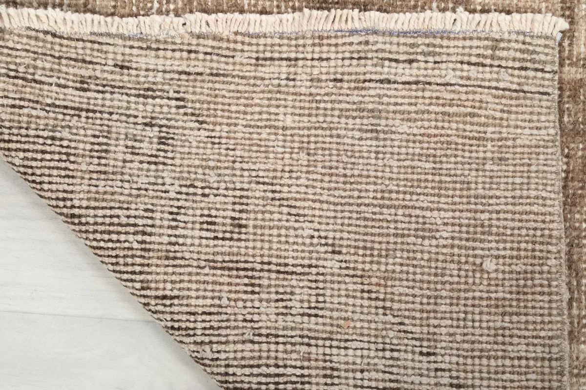 View of the back of the hand-knotted wool runner rug, showcasing the cotton foundation.