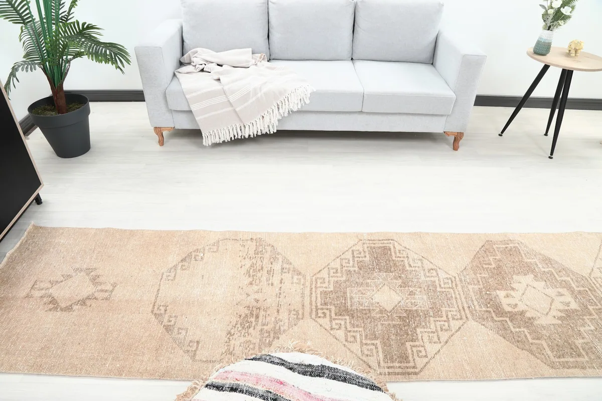 Overhead view of the tan runner rug in a room, highlighting its length and geometric design elements.