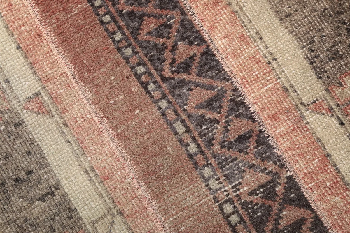 Detailed view of the hand-knotted wool pile and intricate geometric patterns in the rug's center.