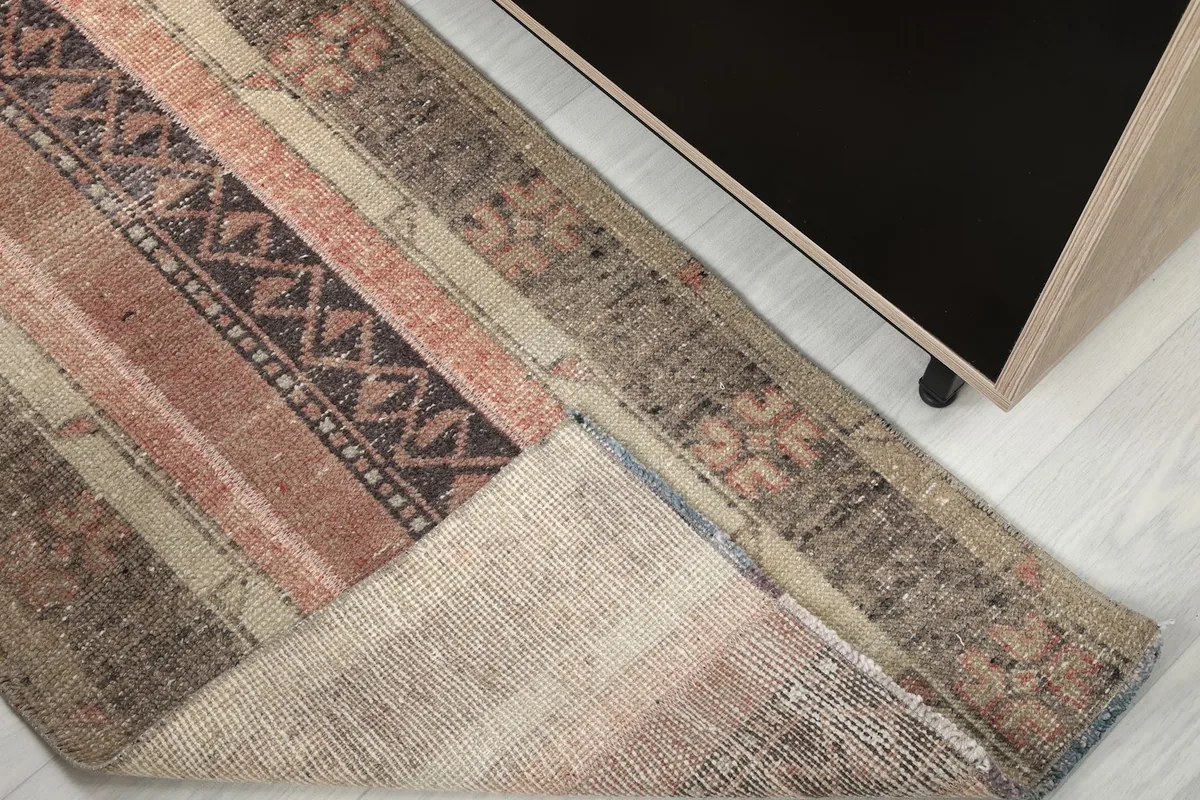 Corner view of the runner rug revealing the cotton foundation and the back of the hand-knotted construction.